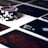 A stack of poker chips with a distinctive black and white pattern is placed on a table covered with several playing cards. The cards are dark with red and white symbols, creating a bold contrast against the lighter surface.