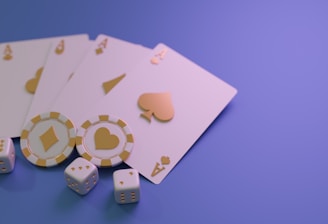 A set of playing cards displaying four aces is laid out on a surface. Alongside them, there are two poker chips with heart and diamond symbols, and three six-sided dice showing different numbers. The background is a smooth gradient of purple, creating a thematic gaming or casino atmosphere.
